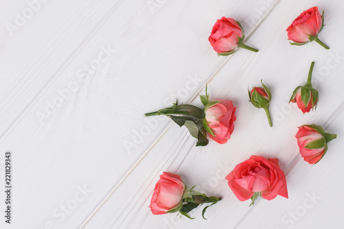 Fototapeta Naklejka Na Ścianę i Meble -  Roses sprinkled on white wooden table. Top view, flat lay.