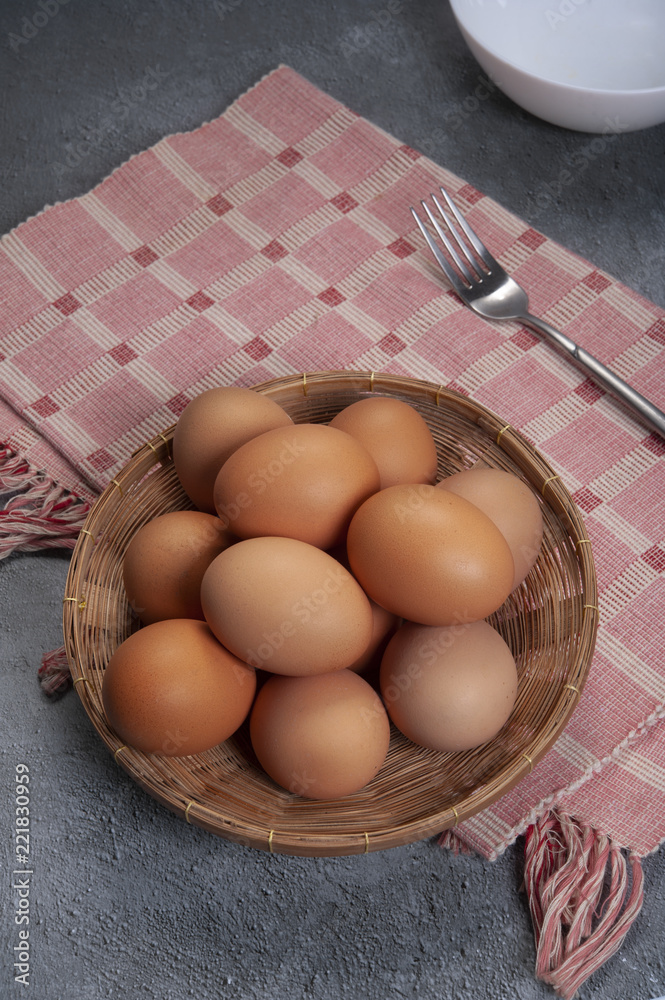Fresh chicken eggs in the basket for cooking or dessert on grey background Fresh chicken eggs in the basket for cooking or dessert on grey background