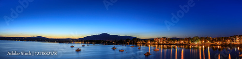 Magog town at night in reflections of Memphremagog lake. Canadian romantic landscape with mountains, lake, night sky and awesome water background. photo