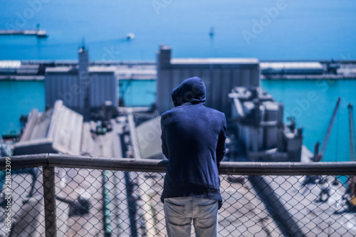 6363518 The man is staying and looking at the factories