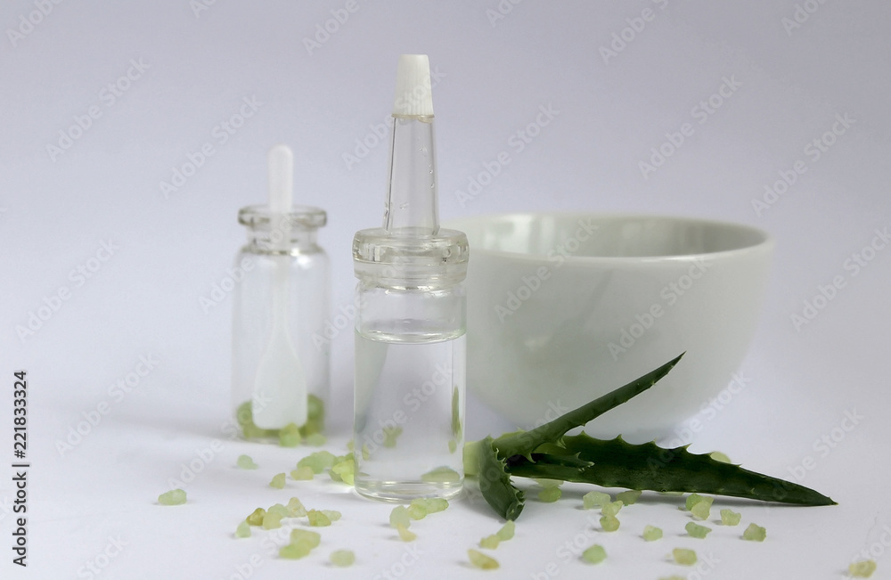 Essential oil for beauty. Cosmetic ingredients and aloe stand on a light background Essential oil for beauty. Cosmetic ingredients and aloe stand on a light background