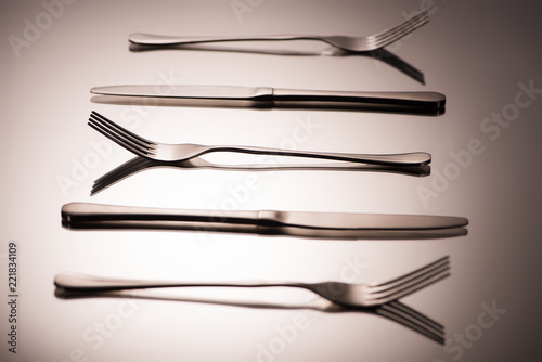 close-up view of shiny forks and knives arranged on grey