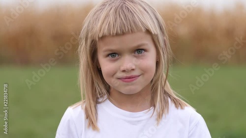Cute smile child girl portrait posing on nature - happy childhood