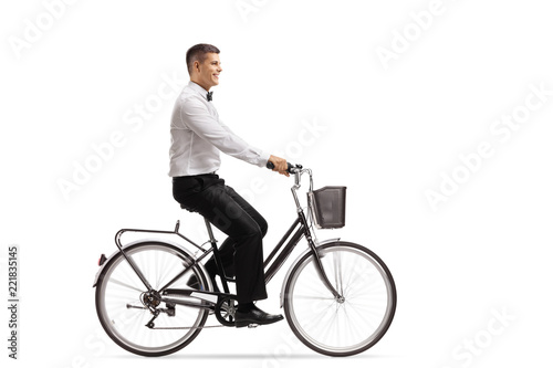 Young man in a tux riding a bicycle