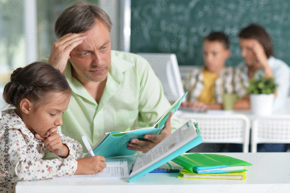 Fototapeta premium Portrait of Father helps his cute little daughter