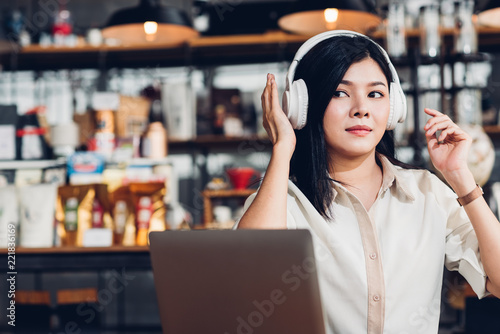 Lifestyle freelance woman he using earphones listening music during working on laptop computer