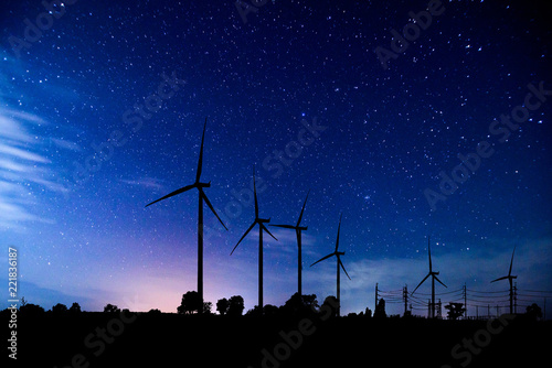 Eco power. silhouette Wind turbines generating electricity with milky way. photo