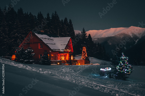 Fotografia Christmas cottage in dark winter night in mountains