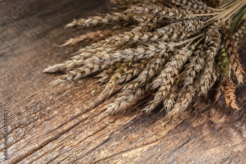 Wheat ears on a wooden background. Vintage composition.