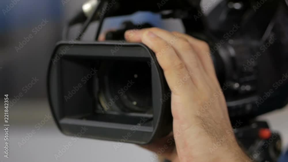 The cameraman is working behind the camera. The cameraman is working behind the camera.