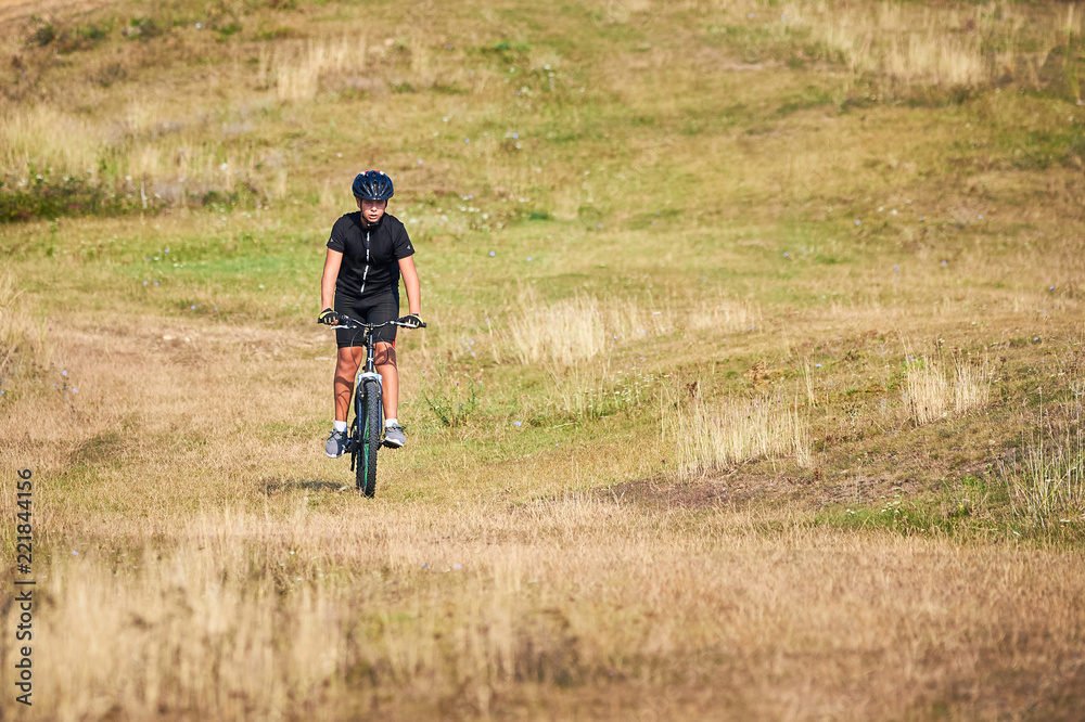 Young Cyclist Riding the Bike on the hill