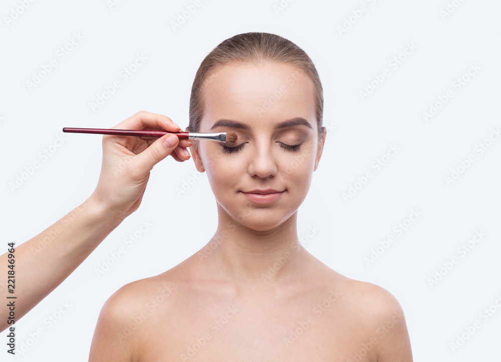 Make-up artist applying eye shadow on female eyelid Make-up artist applying eye shadow on female eyelid