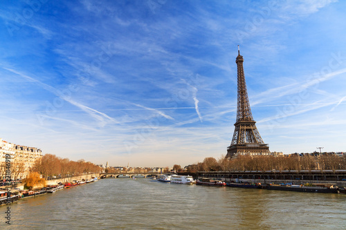 Beautiful Eiffel tower at the Seine river with a dramatic sky in winter