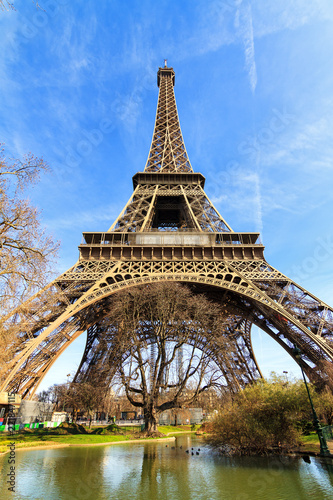 Beautiful view of the Eiffel tower seen from the park close at it in Paris © dennisvdwater