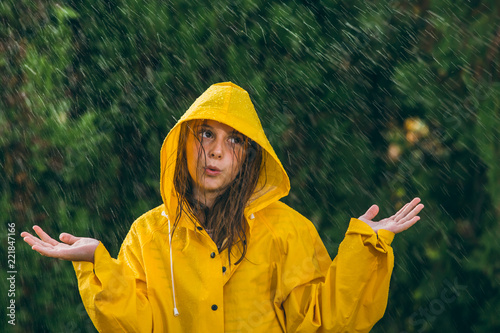 girl playing out in the rain wearing yellow raincoat