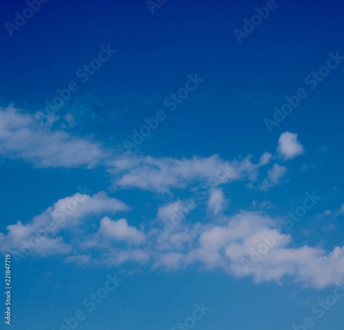 The thin white cloudscape in the bright blue sky.