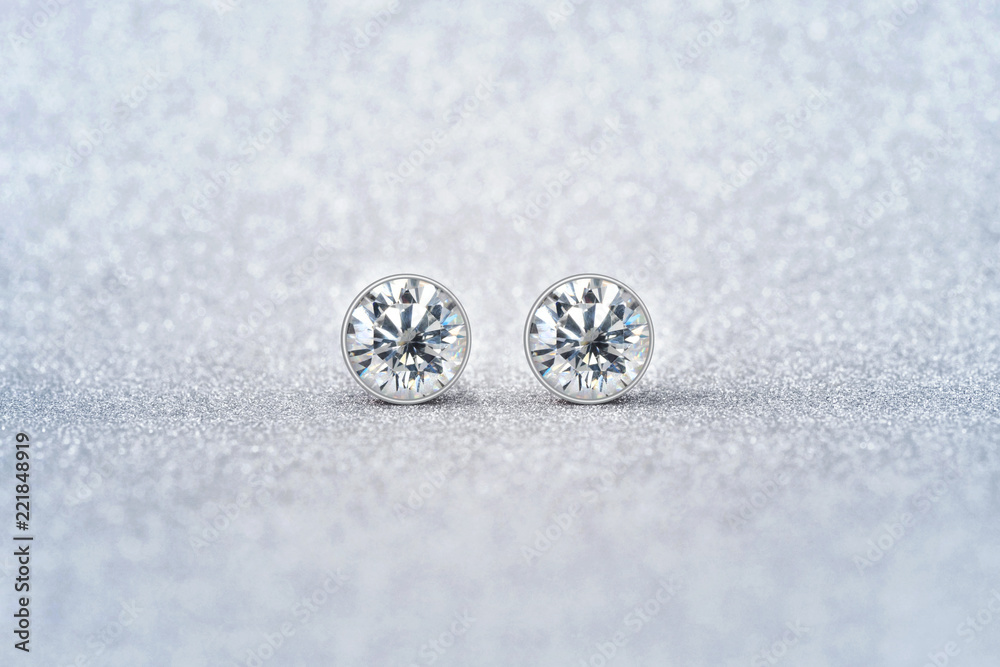 beautiful white diamond stud earrings with reflection on background beautiful white diamond stud earrings with reflection on background