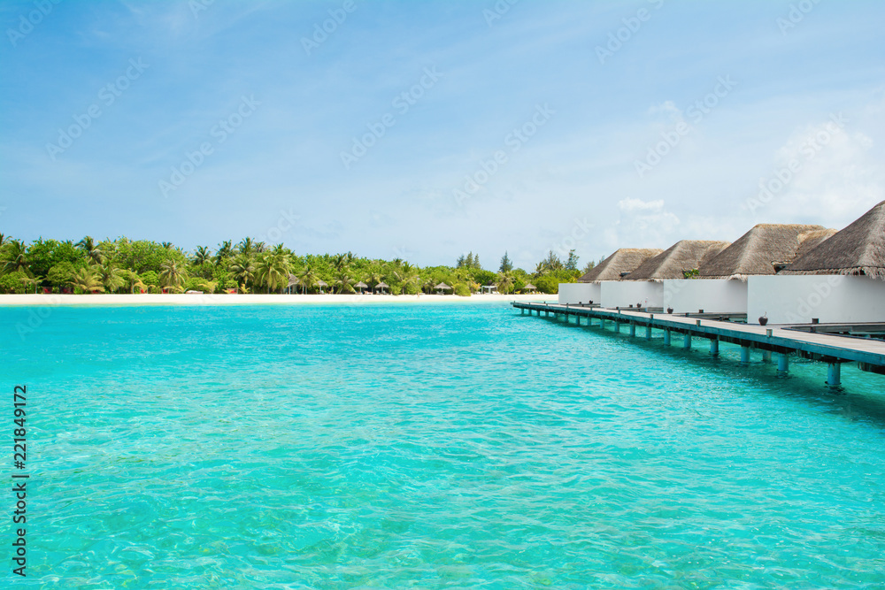 Beautiful sandy beach with sunbeds and umbrellas in Indian ocean, Maldives island Beautiful sandy beach with sunbeds and umbrellas in Indian ocean, Maldives island