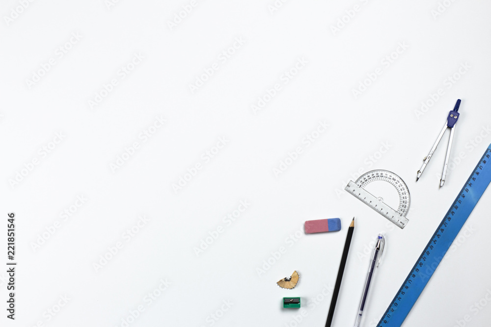 A close-up photo of stationary set: pen, pencil, compass, rubber, protractor and etc. on the white background on the table in office, school or university. A workspace of student or an office worker. A close-up photo of stationary set: pen, pencil, compass, rubber, protractor and etc. on the white background on the table in office, school or university. A workspace of student or an office worker.