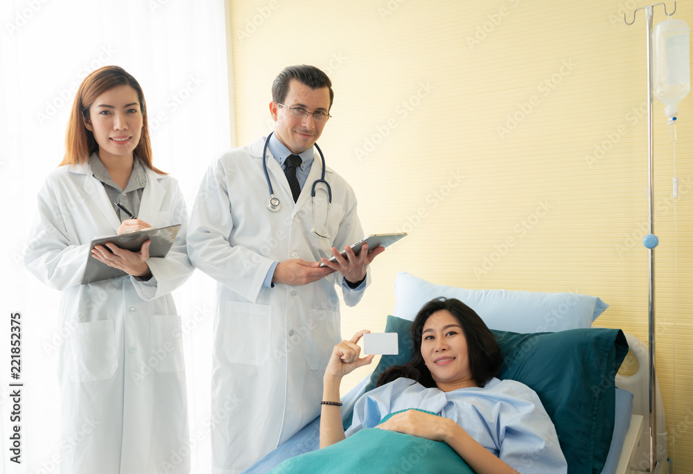 Smiling doctor and patient be happy when using blank credit card for paying medical bills.
