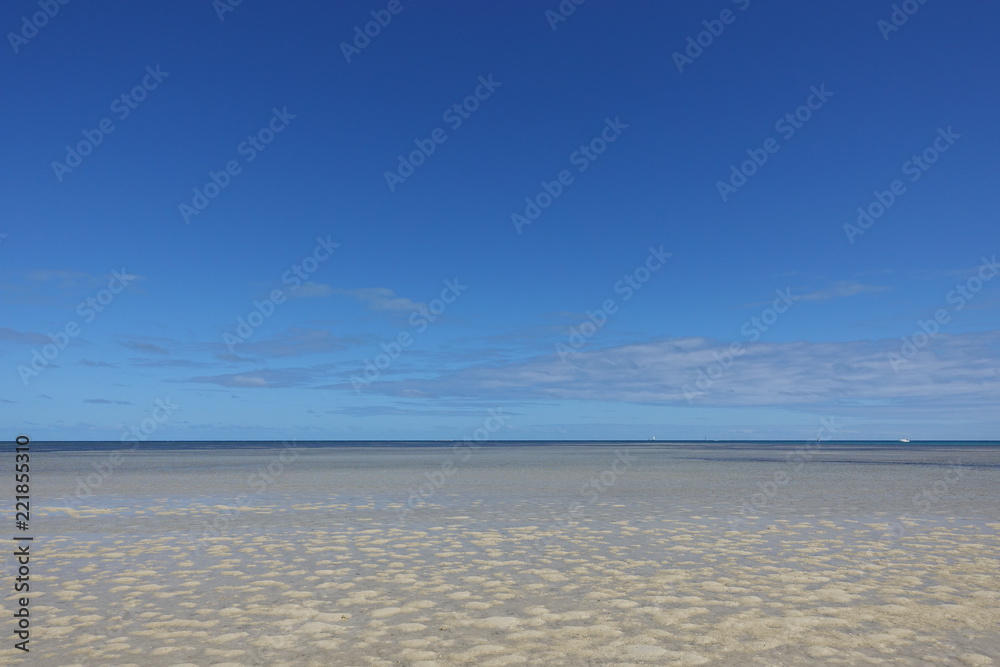 青い空と遠浅の砂浜のビーチ