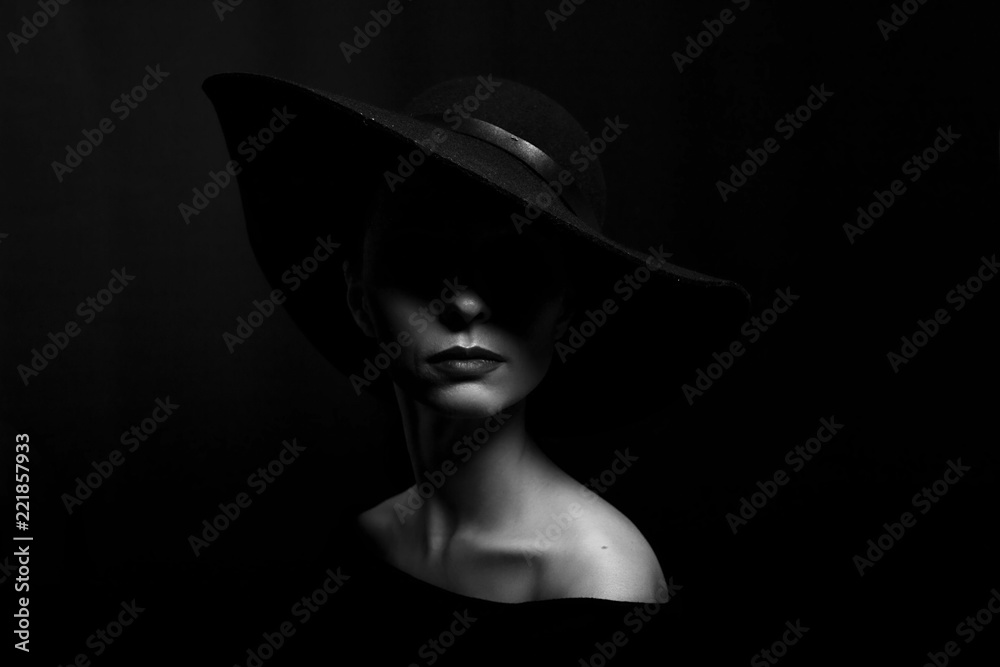 Fototapeta w stylu glamour. Portret kobiety w czarnym kapeluszu na czarnym tle.
