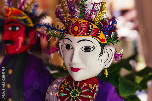 Two Indonesian dolls with white and red faces in traditional folk costumes photo