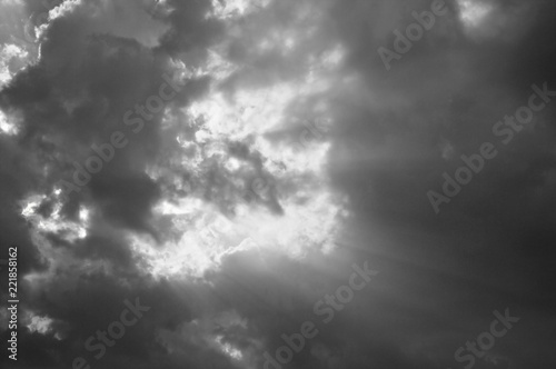 sunbeam spreading light through dark cloud on sky