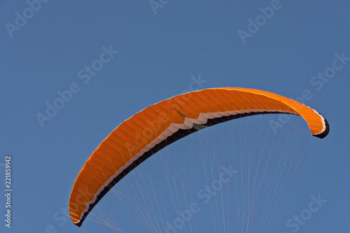 orange parachute with ropes and blue sky