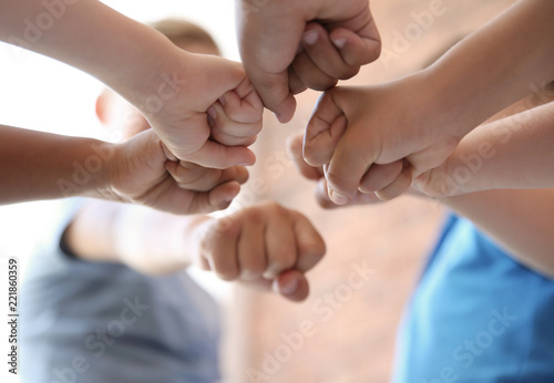 Little children putting their hands together on blurred background. Unity concept © New Africa