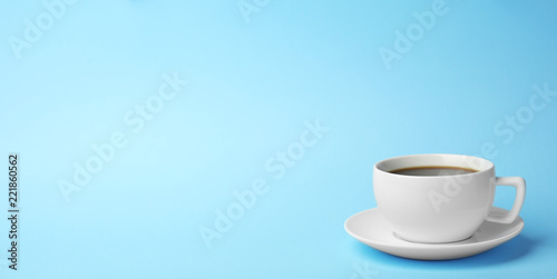 Fototapeta samoprzylepna Biała ceramiczna filiżanka z gorącą aromatyczną kawą na koloru tle