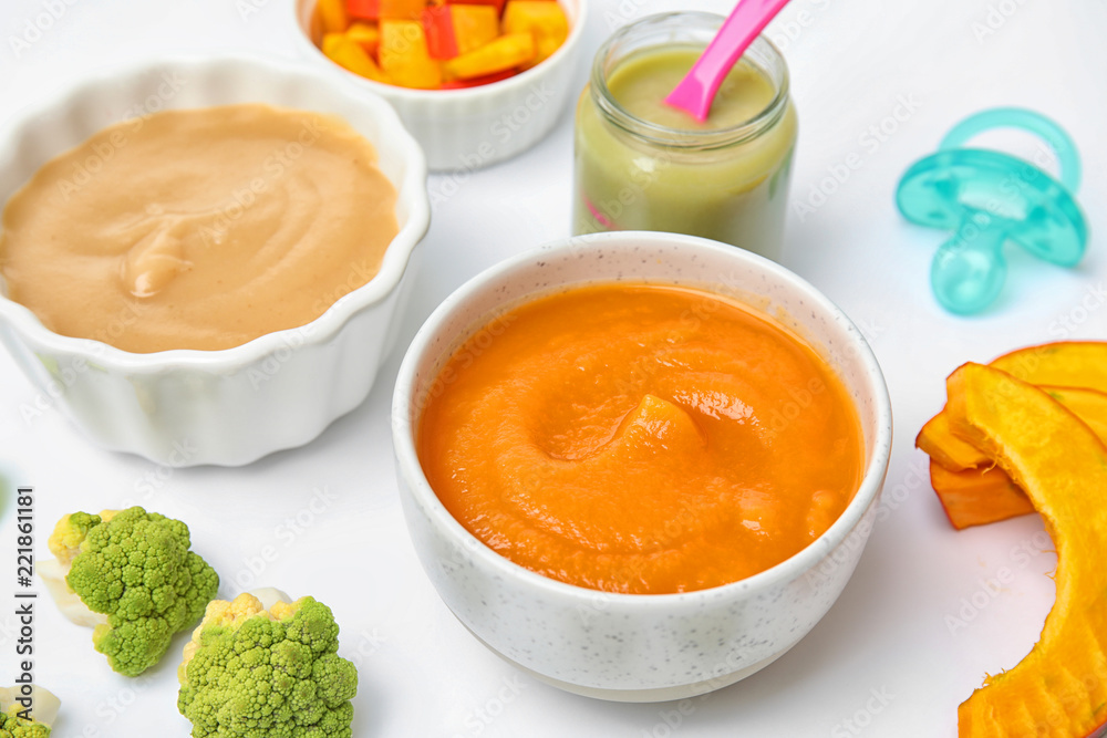 Bowls with healthy baby food on white background Bowls with healthy baby food on white background