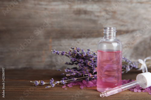 Fototapeta Naklejka Na Ścianę i Meble -  Bottle with aromatic lavender oil on wooden table. Space for text