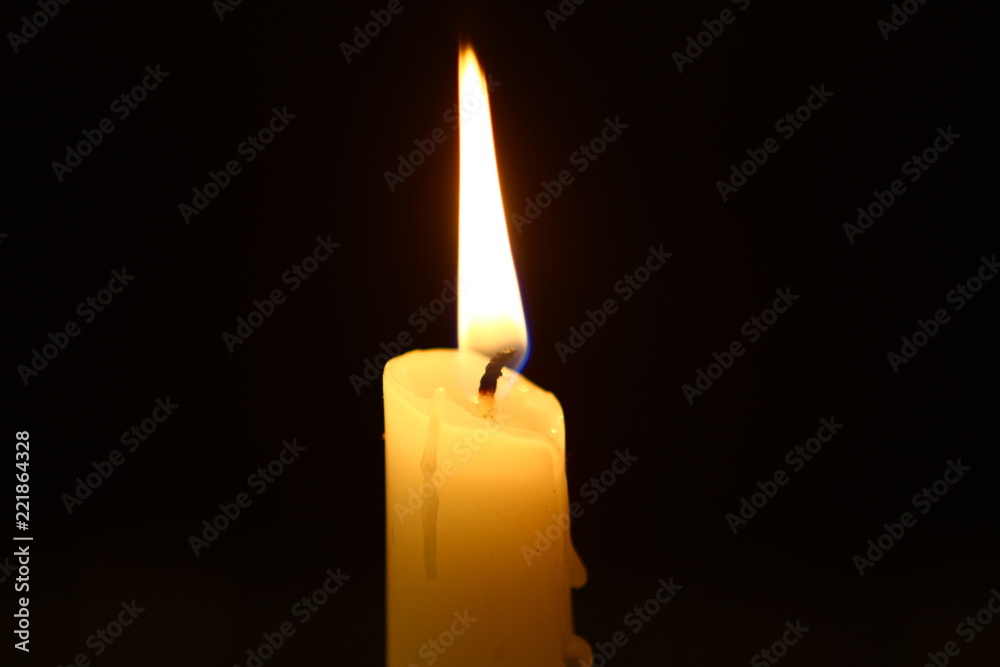 big wax flaming candle with vivid fire against heavy black background. big wax flaming candle with vivid fire against heavy black background.