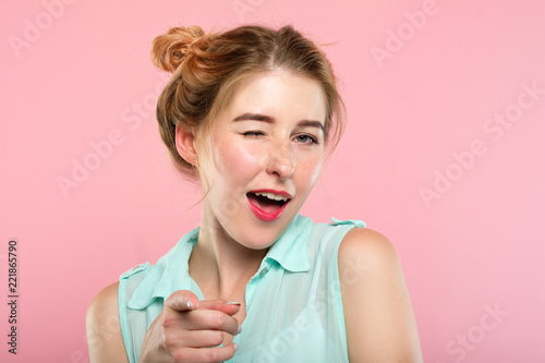 emotion expression. smiling woman pleased with herself. young beautiful girl winking. portrait on pink background.