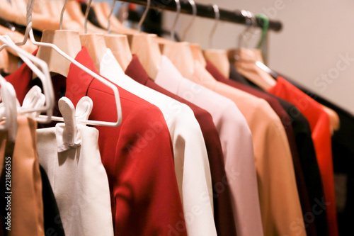 Close up of many colors of fashionable business suits hanging on rack for sale in store.