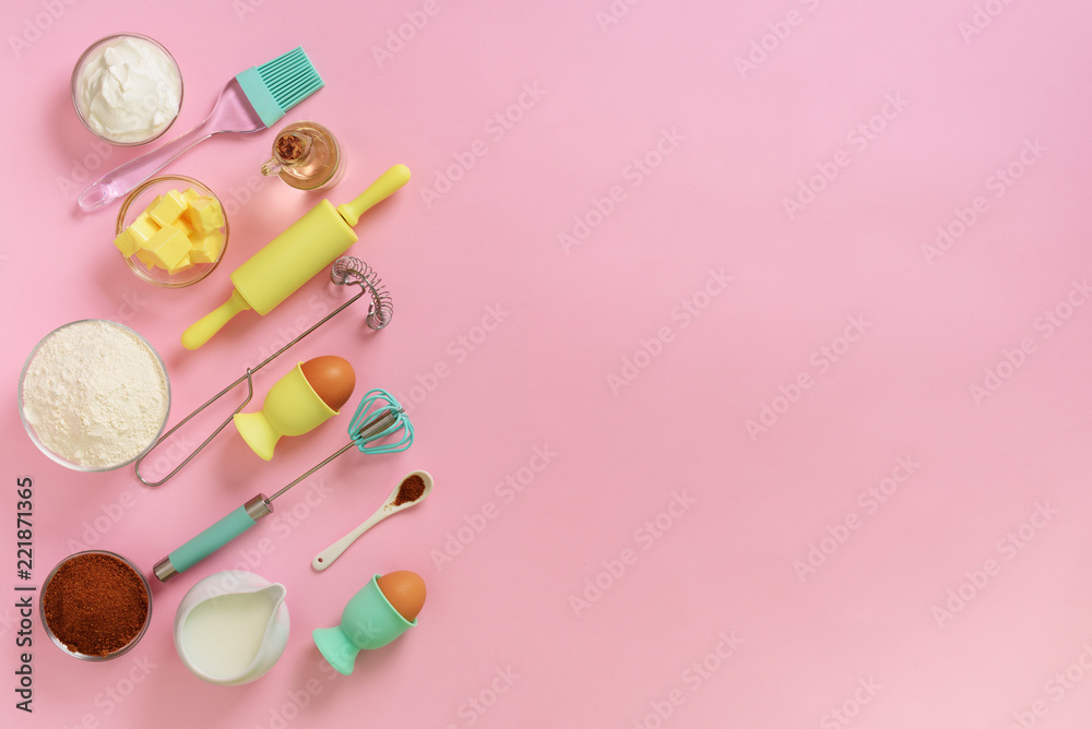 Butter, sugar, flour, eggs, oil, spoon, rolling pin, brush, whisk, towel over pink background. Bakery food frame, cooking concept. Ingredients on kitchen table. Top view, copy space. Flat lay