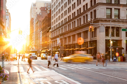 Photography Busy intersection of 23rd Street and 5th Avenue in Manhattan is crowded with people and traffic as the sun sets in the background