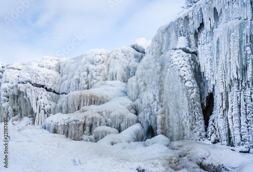 A frozen waterfall with ice in blue and white color in winter. Winter background. Jagala Waterfall, Estonia.
