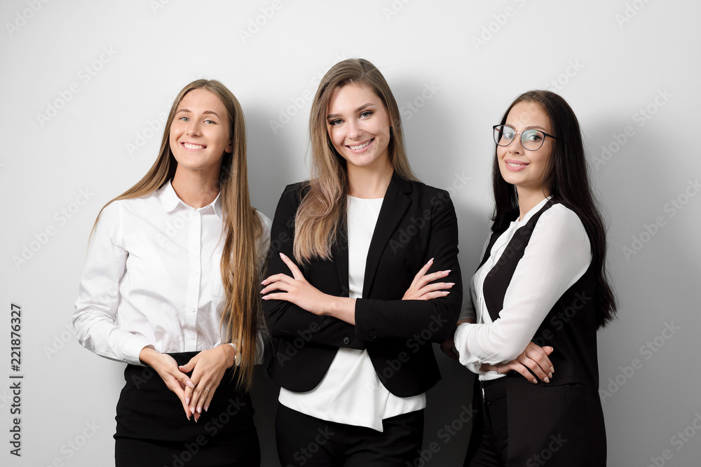 Three beautiful young smiling woman in business clothes on a white background. Three beautiful young smiling woman in business clothes on a white background.