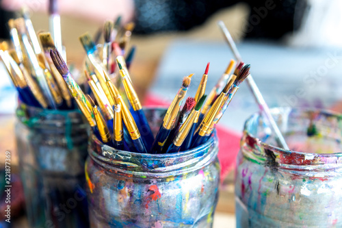 Coloured paint brushes in a jar