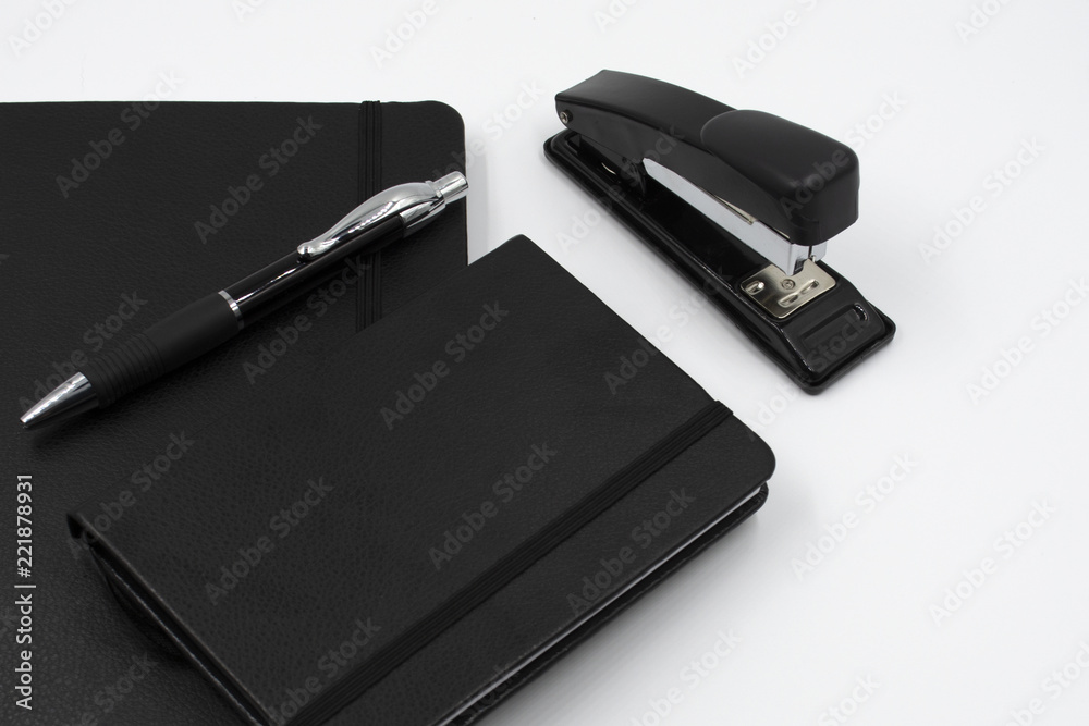 Conjunto de libreta, bolígrafo, móvil y grapadora de color negro en fondo blanco. Oficina Conjunto de libreta, bolígrafo, móvil y grapadora de color negro en fondo blanco. Oficina