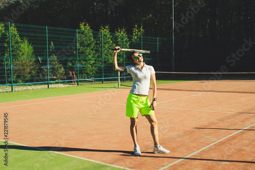 Portrait of girl with dart hair play tennis. Background tennis court.White t-shirt polo and yellow shorts.Sport shooting.