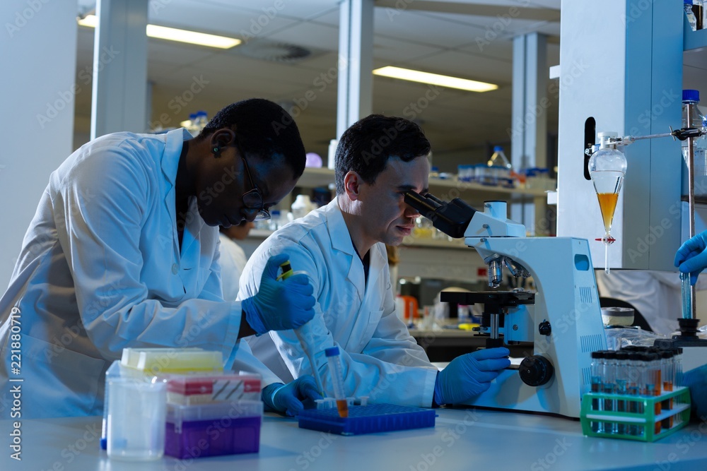 Male scientists experimenting in laboratory Male scientists experimenting in laboratory