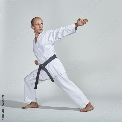 Formal exercises of karate are trained by an adult athlete with a black belt