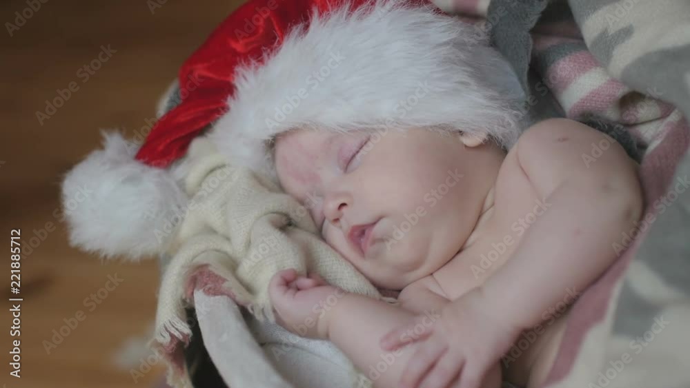Christmas, newborn baby in a Santa Claus hat sleeping lying in a basket