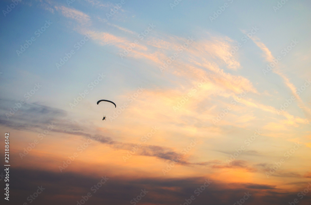 Ione paraglider flies high in the sky at sunset.Extreme sport.