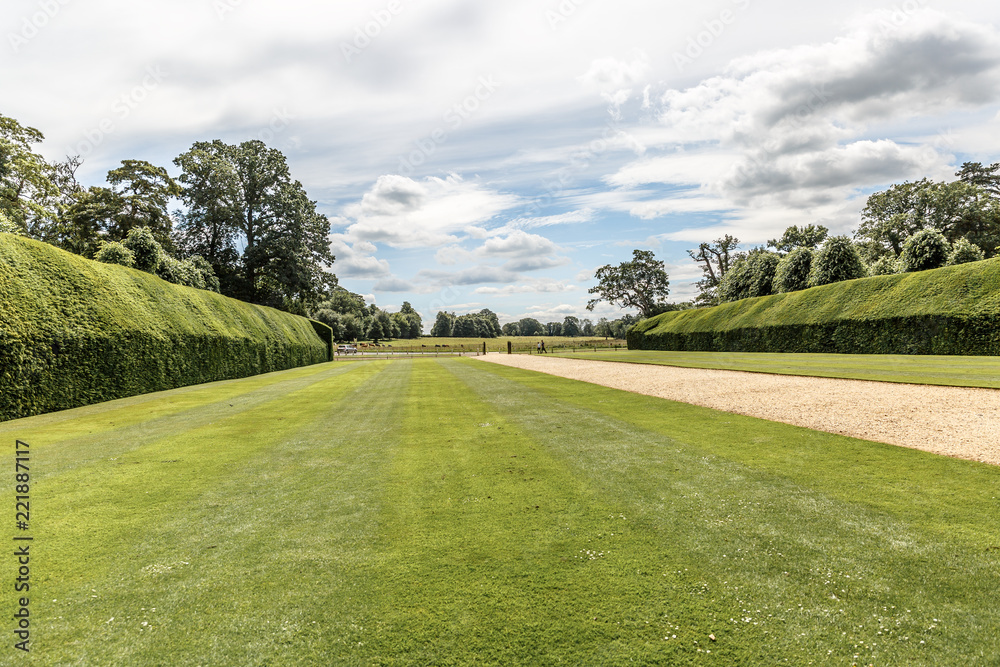 Beautiful view of a neat lawn with hedges on the sides in blickling hall, on a sunny day