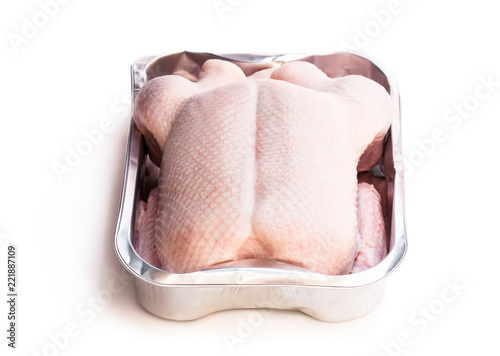 Raw whole  duck in a roasting oventray isolated on white photo