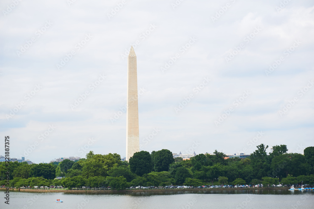 The Washington Monument and tidal basin in summer. A peddleboat is in the water. 